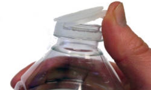 Cristaline met les gaz sur le bouchon attaché à la bouteille